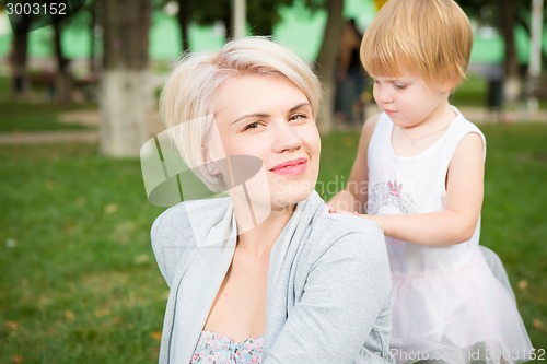 Image of portrait of beautiful mother and kid girl outdoors in park