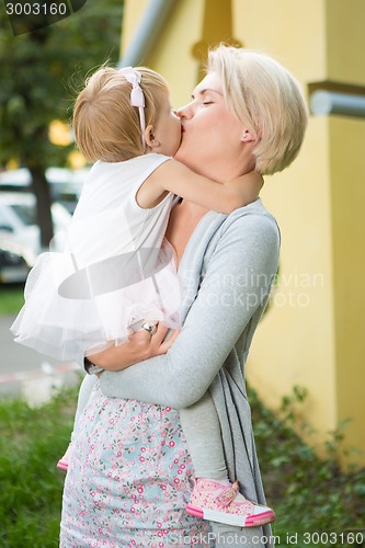 Image of mother kissing her daughter