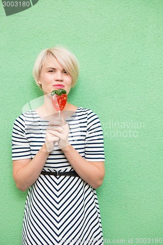 Image of Young sexy woman sucking lollipop. 