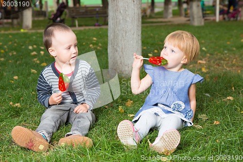 Image of Adorable little kids with colorful lollipops