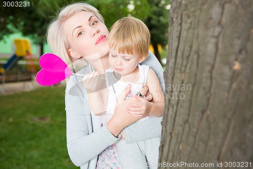 Image of portrait of beautiful mother and kid girl outdoors in park