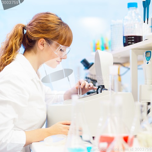 Image of Attractive young scientist pipetting.