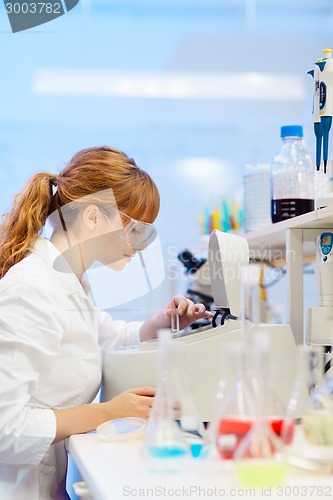 Image of Attractive young scientist pipetting.