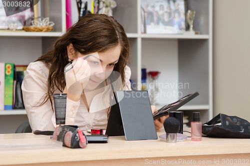 Image of Office worker paints the eyebrows