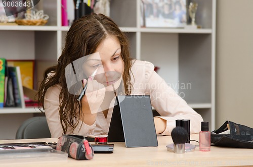 Image of Girl gets concealer on eyelids