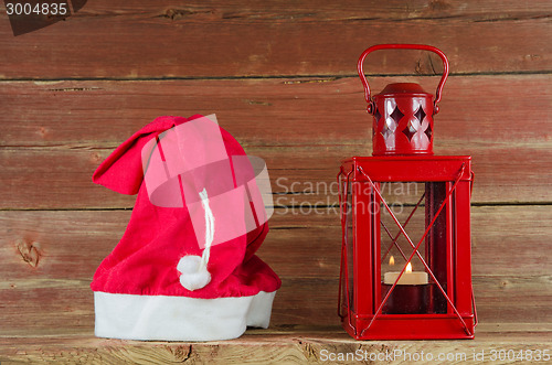 Image of Santa Claus cap and red Christmas lantern