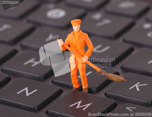 Image of Miniature worker is cleaning a keyboard