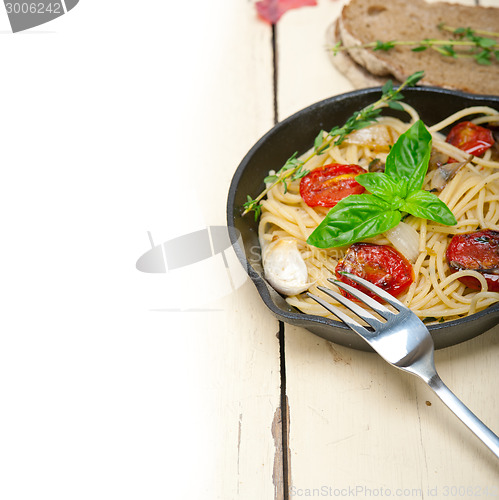 Image of spaghetti pasta with baked cherry tomatoes and basil 