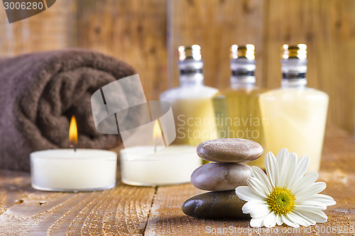 Image of zen basalt stones and spa oil with candles on the wood