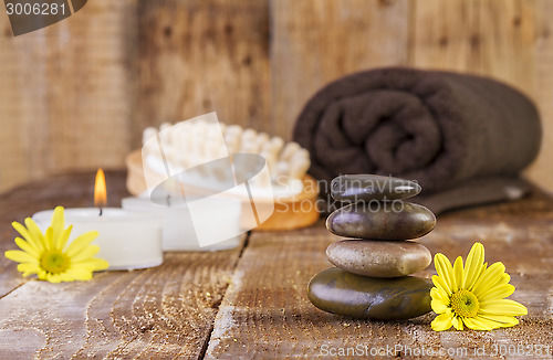 Image of zen basalt stones and spa oil with candles on the wood