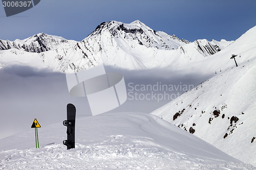 Image of Warning sing and snowboard on off-piste slope