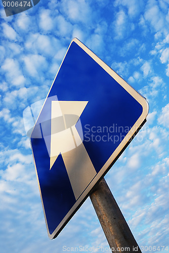 Image of one way sign under blue sky