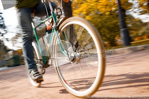Image of Man with bicycle riding country road