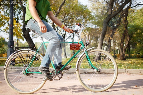 Image of Close-up of young man riding bicycle in park