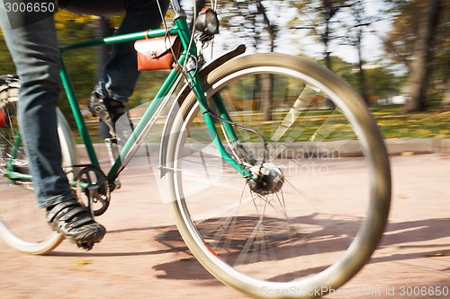 Image of Close-up of young man riding bicycle in park