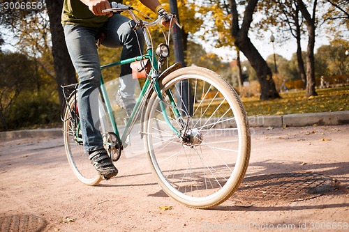 Image of Close-up of young man riding bicycle in park