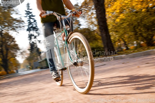 Image of Man with bicycle riding country road