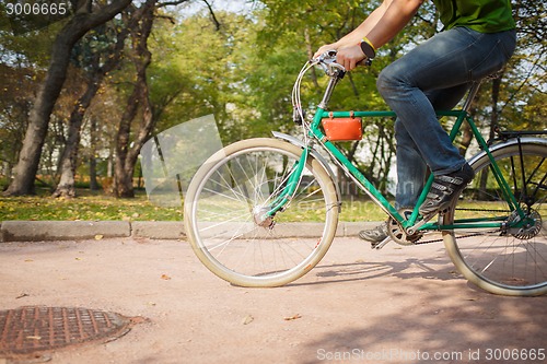 Image of Close-up of young man riding bicycle in park