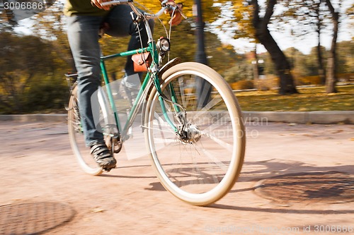 Image of Close-up of young man riding bicycle in park