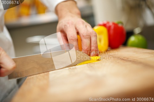 Image of man's hands cutting pepper. Salad preparation