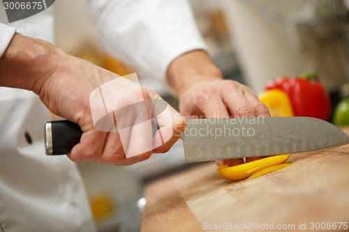 Image of man's hands cutting pepper. Salad preparation