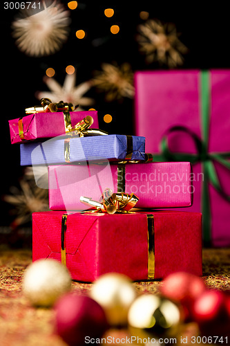 Image of Gift Parcels Piled up amidst Baubles and Stars