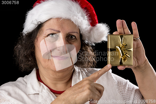 Image of Mature Woman with Red Cap Pointing at Golden Gift