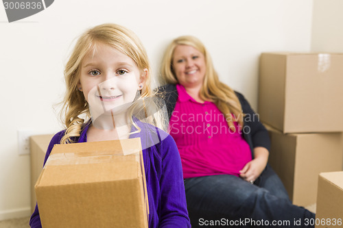 Image of Young Mother and Daughter In Empty Room With Moving Boxes