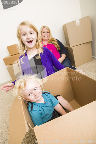 Image of Young Family In Empty Room Playing With Moving Boxes