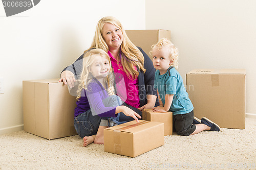 Image of Young Family In Empty Room with Moving Boxes