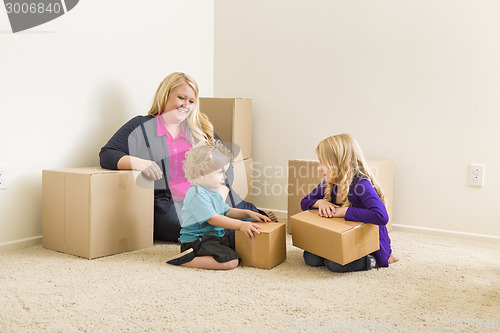 Image of Young Family In Empty Room with Moving Boxes