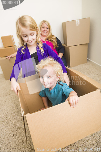 Image of Young Family In Empty Room Playing With Moving Boxes