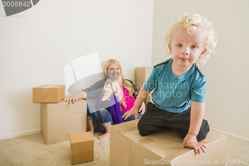 Image of Young Family In Empty Room Playing With Moving Boxes