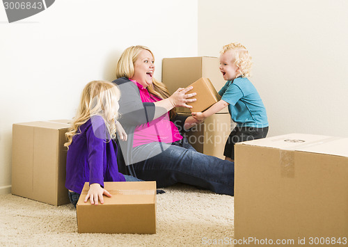 Image of Young Family In Empty Room Playing With Moving Boxes