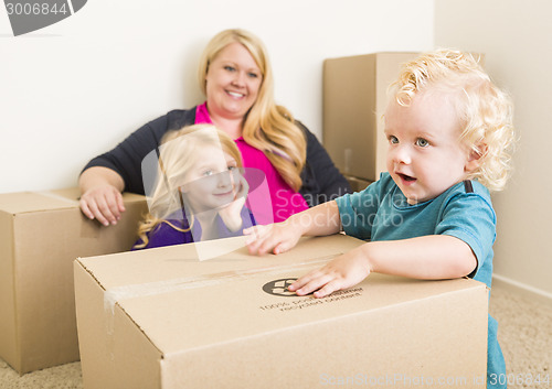 Image of Young Family In Empty Room Playing With Moving Boxes