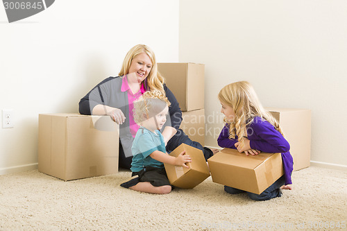 Image of Young Family In Empty Room with Moving Boxes