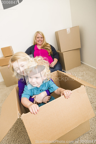 Image of Young Family In Empty Room Playing With Moving Boxes