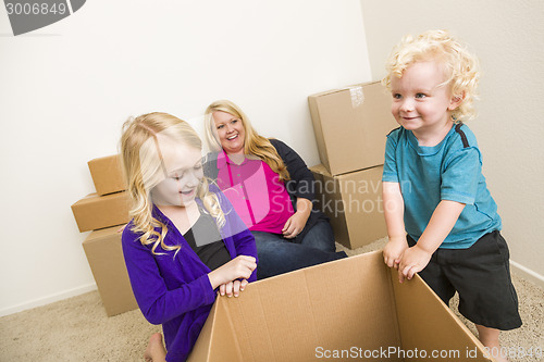 Image of Young Family In Empty Room Playing With Moving Boxes