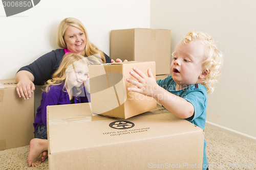 Image of Young Family In Empty Room Playing With Moving Boxes