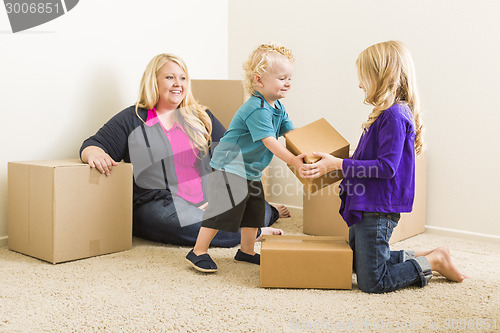 Image of Young Family In Empty Room with Moving Boxes