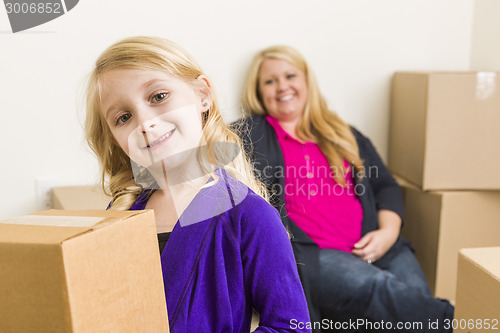 Image of Young Mother and Daughter In Empty Room With Moving Boxes