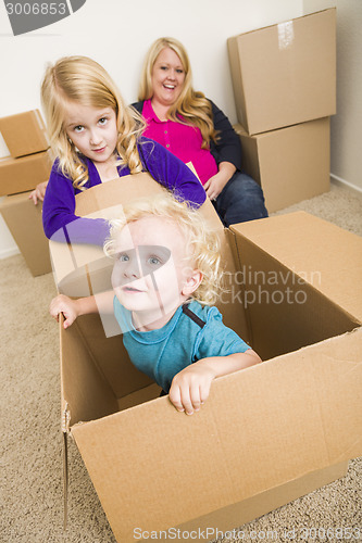 Image of Young Family In Empty Room Playing With Moving Boxes