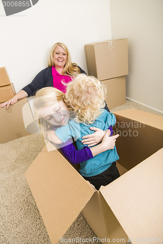 Image of Young Family In Empty Room Playing With Moving Boxes