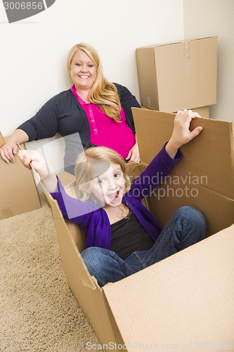 Image of Young Family In Empty Room Playing With Moving Boxes