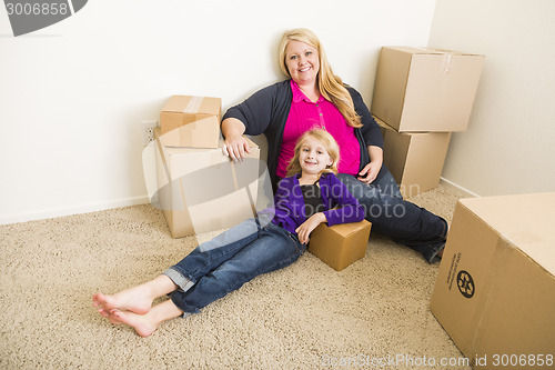 Image of Young Mother and Daughter In Empty Room With Moving Boxes