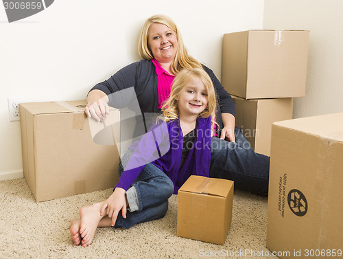 Image of Young Mother and Daughter In Empty Room With Moving Boxes