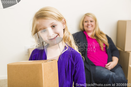 Image of Young Mother and Daughter In Empty Room With Moving Boxes