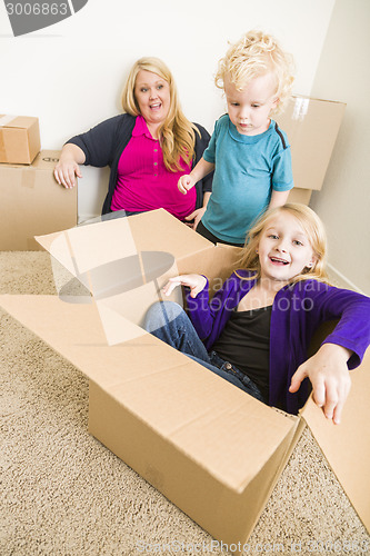 Image of Young Family In Empty Room Playing With Moving Boxes