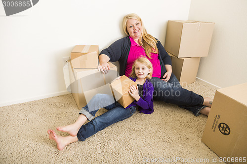 Image of Young Mother and Daughter In Empty Room With Moving Boxes