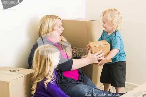 Image of Young Family In Empty Room Playing With Moving Boxes